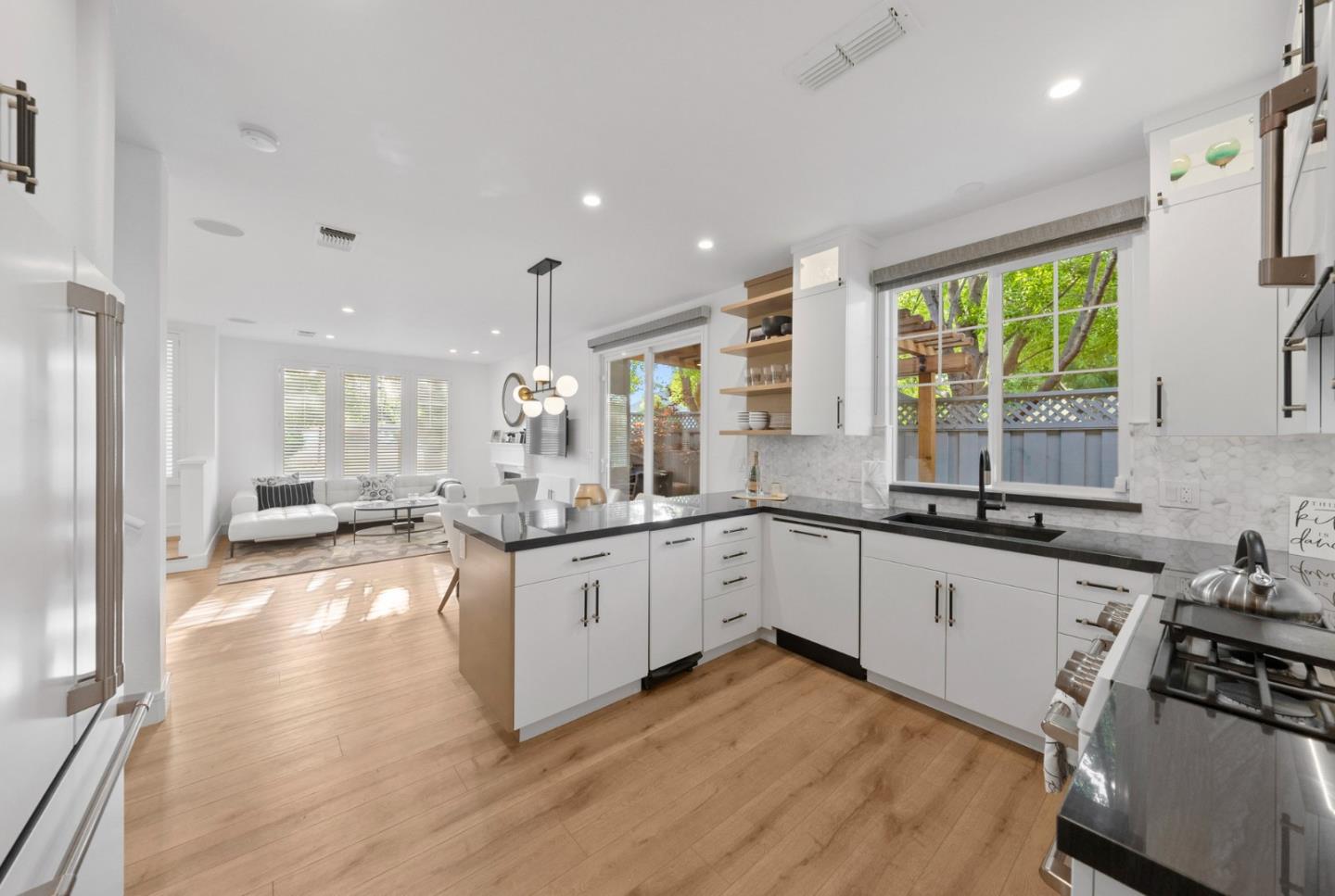 a large kitchen with granite countertop a large counter top appliances a sink and a window