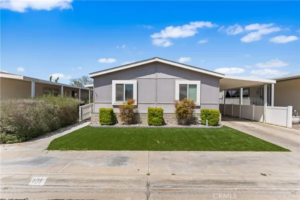 a front view of a house with a yard and potted plants