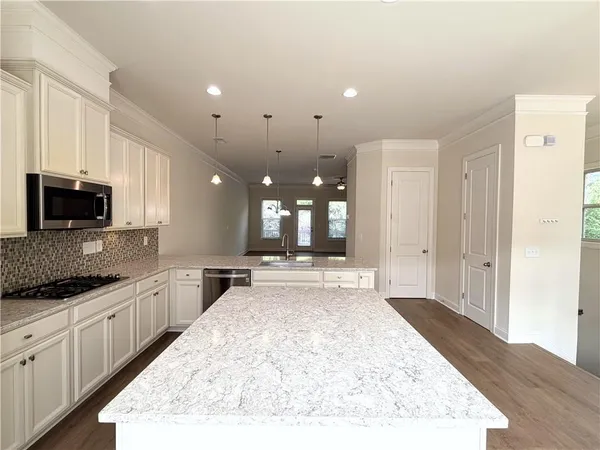 a large kitchen with kitchen island a sink stainless steel appliances and cabinets
