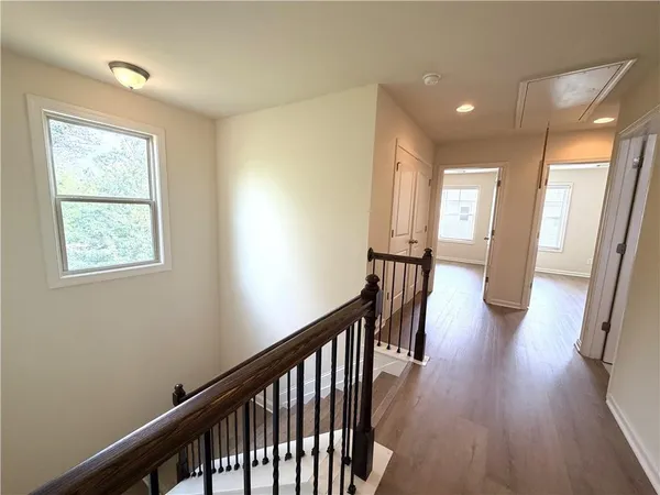a view of a hallway with wooden floor and stairs