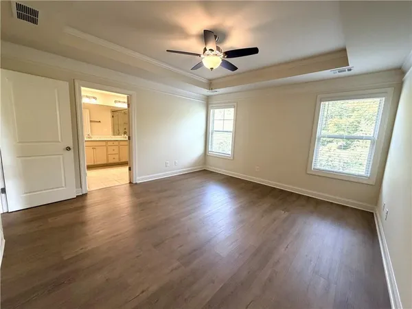 a view of a livingroom with wooden floor and a ceiling fan