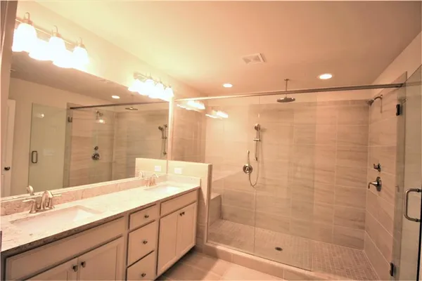 a bathroom with a granite countertop sink mirror and shower