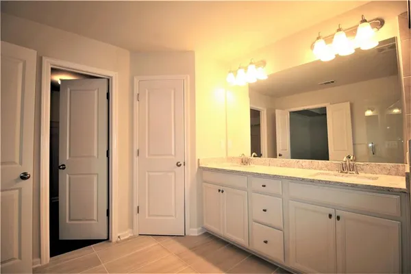 a spacious bathroom with a granite countertop sink mirror and