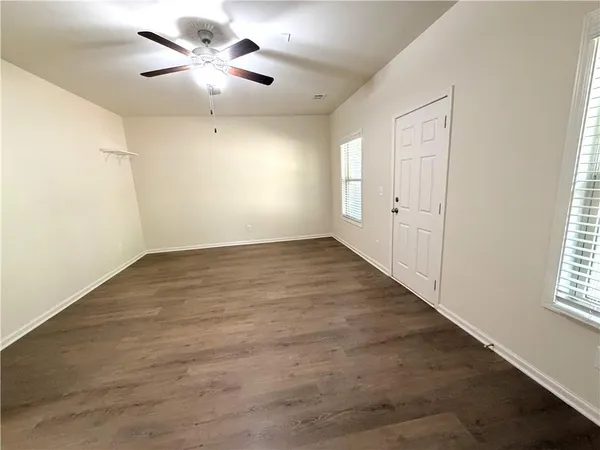 an empty room with fan and windows
