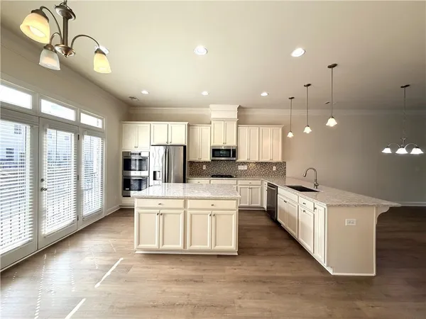 a large kitchen with lots of counter space wooden floor and appliances