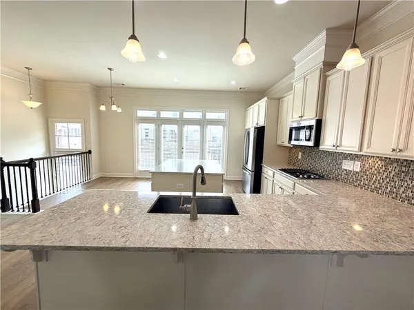 a kitchen with granite countertop a sink a counter top space and living room view