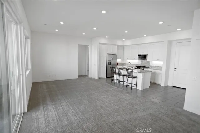 a kitchen with stainless steel appliances kitchen island granite countertop a refrigerator and a stove top oven