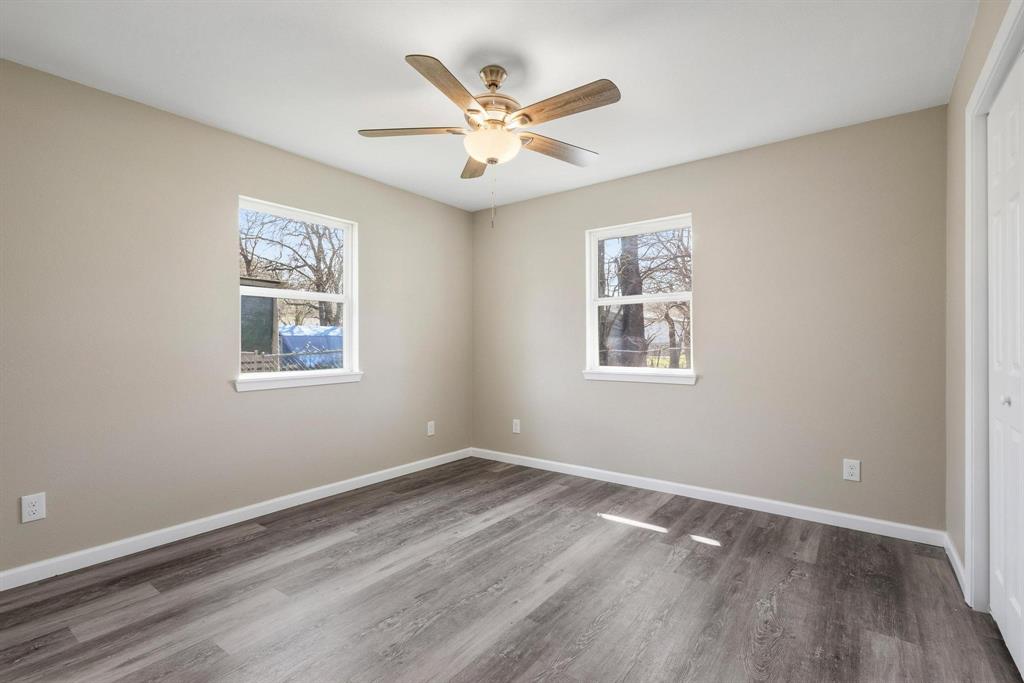 1704 Harris Street Gainesville, TX 76240 - Photo 12 of 21 Empty room with wood finished floors, plenty of natural light, and ceiling fan
