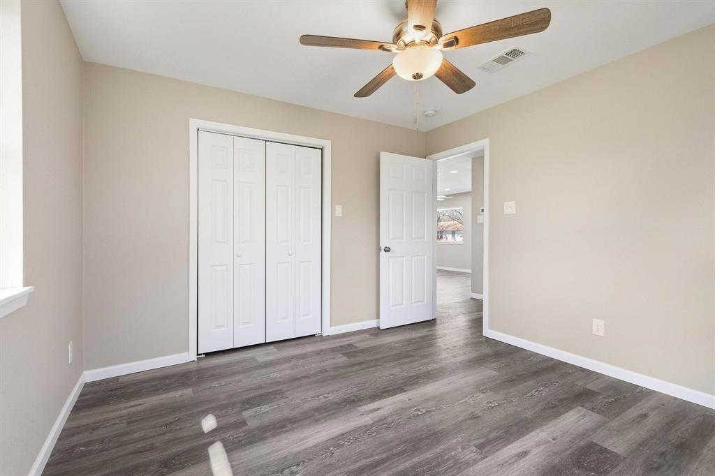1704 Harris Street Gainesville, TX 76240 - Photo 13 of 21 Unfurnished bedroom featuring a ceiling fan, dark wood-style flooring, and a closet