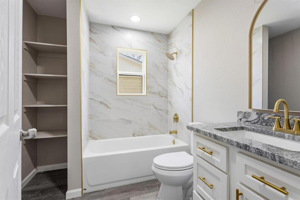 1704 Harris Street Gainesville, TX 76240 - Photo 14 of 21 Bathroom with vanity, shower / tub combination, and light wood-style floors