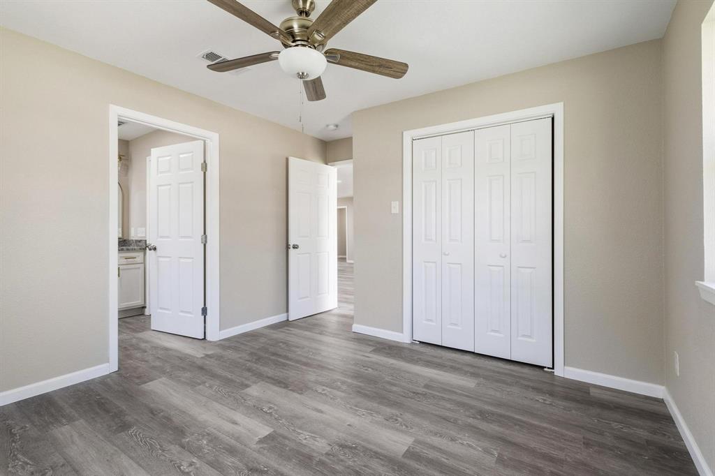 1704 Harris Street Gainesville, TX 76240 - Photo 16 of 21 Unfurnished bedroom featuring a ceiling fan, dark wood-style floors, and a closet