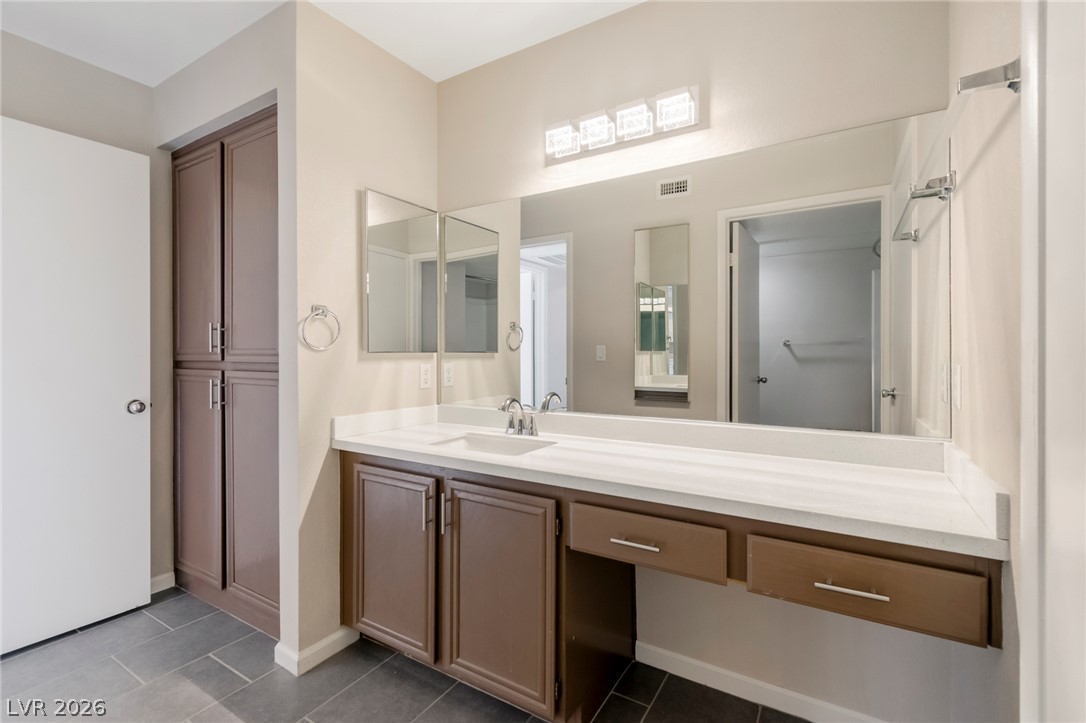 8070 West Russell Road, Unit 2006 Las Vegas, NV 89113 - Photo 17 of 24 Ample counter space and integrated storage create a well-appointed primary bath vanity.