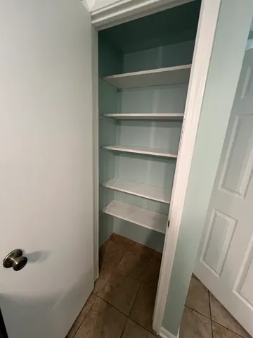 a view of walk in closet with empty racks
