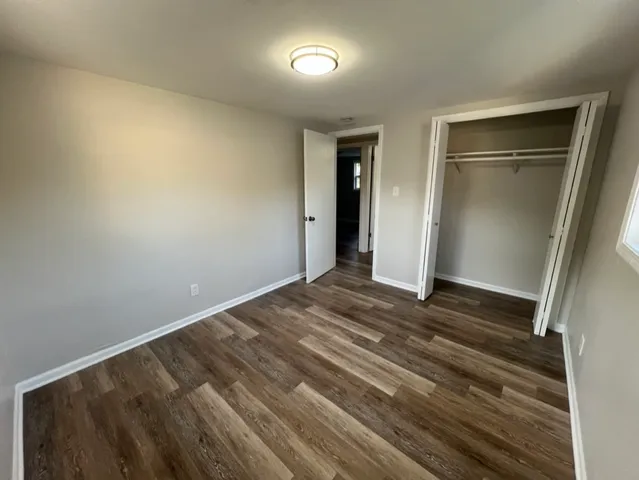 a view of a room with wooden floor and a window
