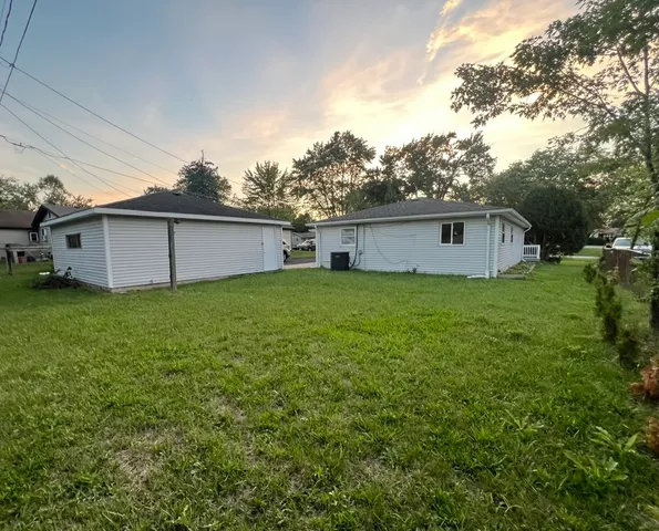 a view of a house with a big yard and large tree