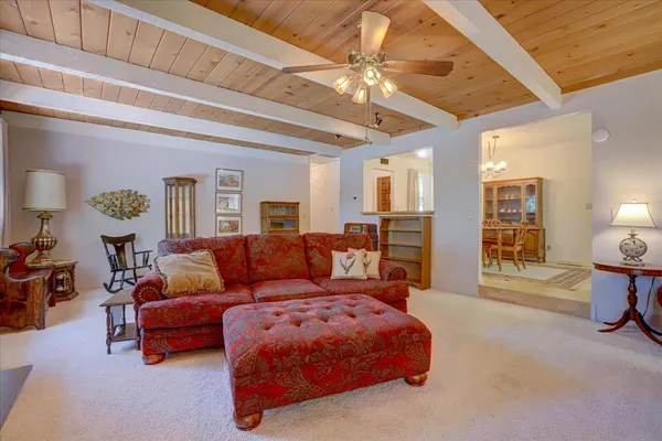 a living room with furniture a flat screen tv and a large window