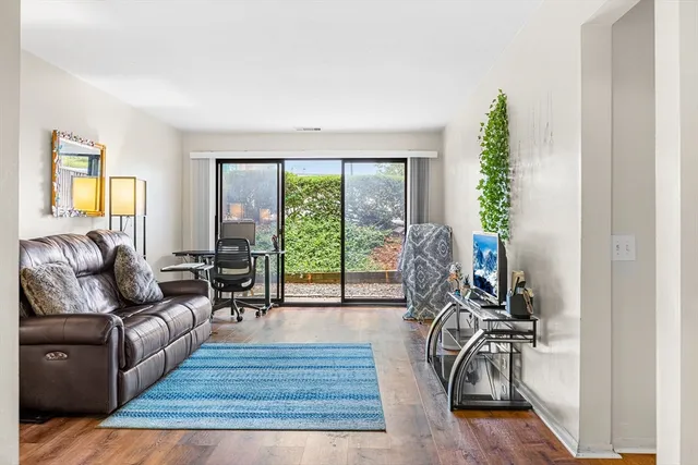 a living room with furniture and a wooden floor