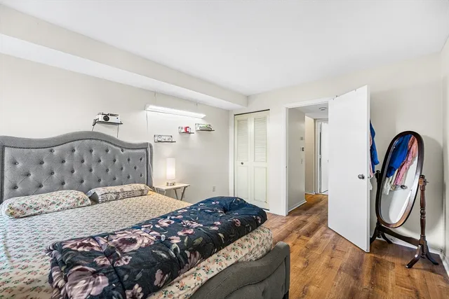 a bedroom with a bed and dresser with mirror