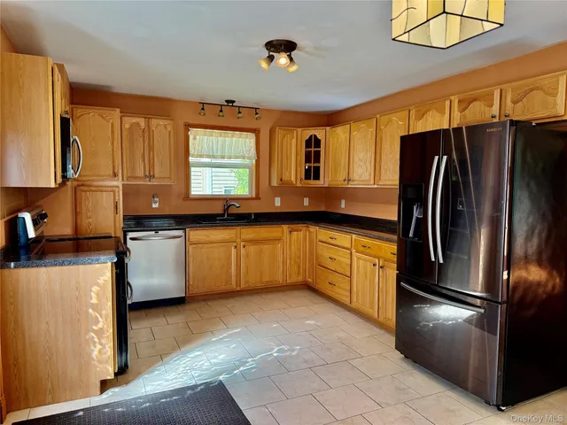 a kitchen with stainless steel appliances a refrigerator sink and cabinets