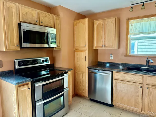 a kitchen with stainless steel appliances granite countertop a stove microwave and sink