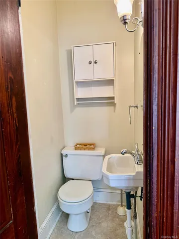 a bathroom with a toilet a sink and mirror