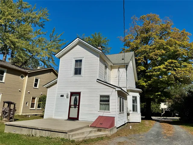a view of a white house with a yard
