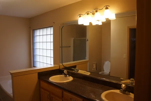 a bathroom with a sink vanity granite and a mirror