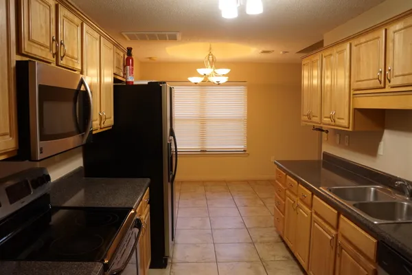 a kitchen with a sink a stove and cabinets