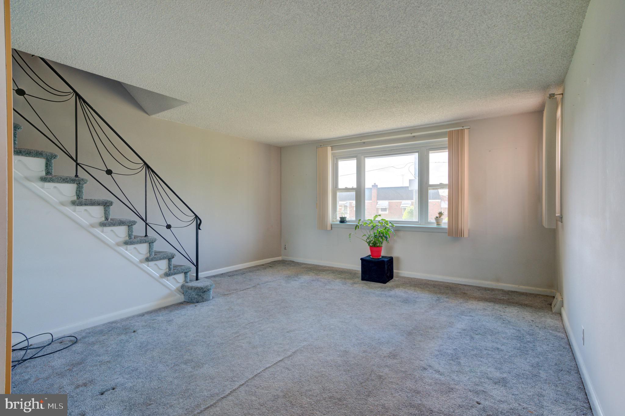 9075 Convent Avenue Philadelphia, PA 19136 - Photo 7 of 17 a view of an empty room with wooden floor and windows