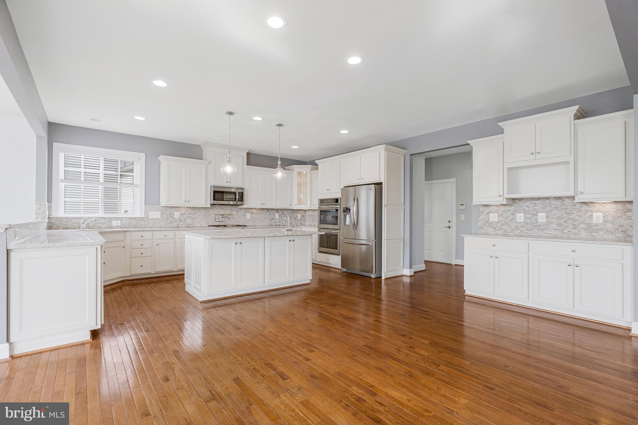 41729 Wakehurst Place Leesburg, VA 20176 - Photo 22 of 71 a large kitchen with cabinets wooden floor and a stainless steel appliances
