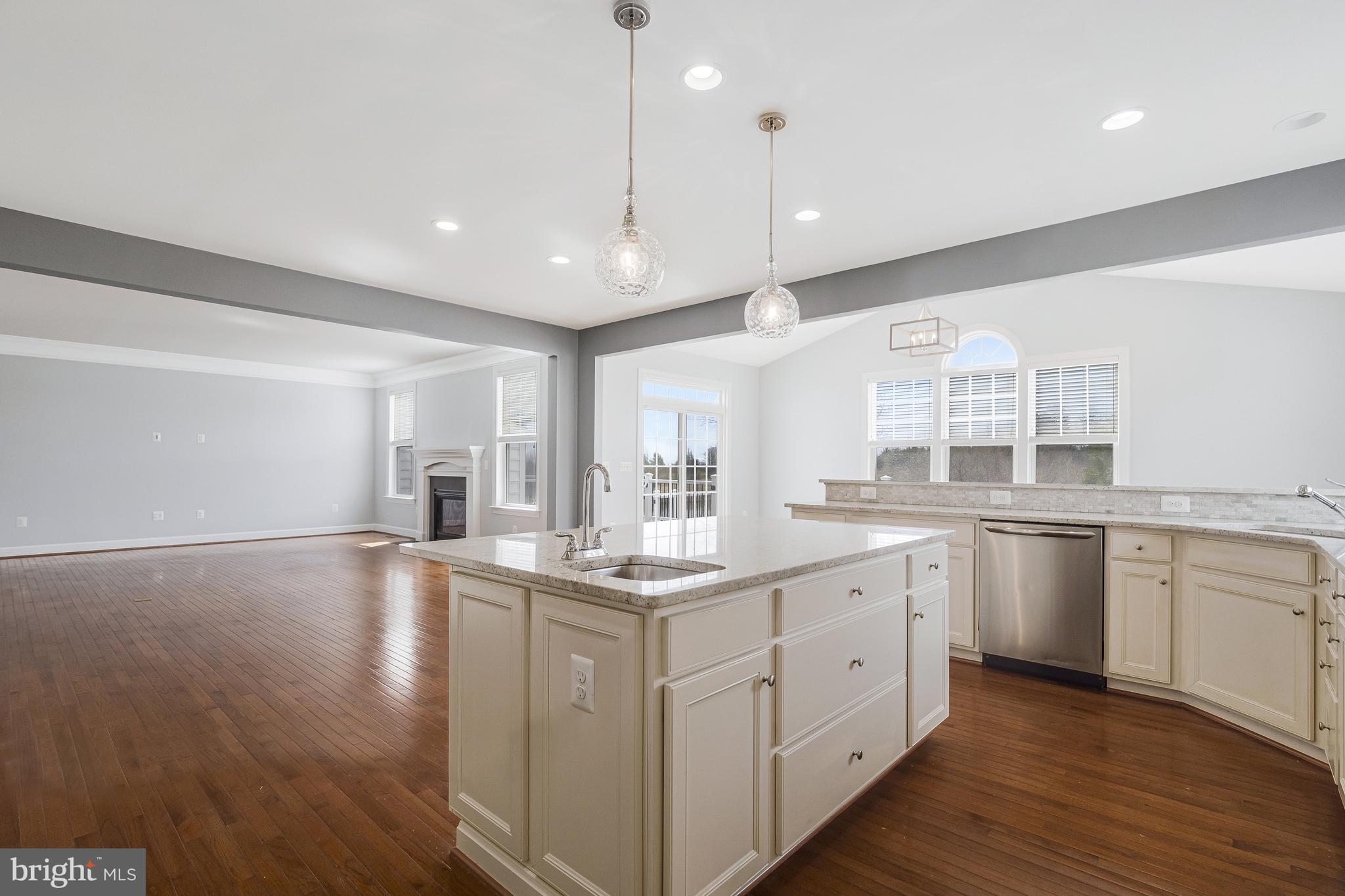 41729 Wakehurst Place Leesburg, VA 20176 - Photo 24 of 71 a large kitchen with kitchen island a sink appliances wooden floor and a counter top space
