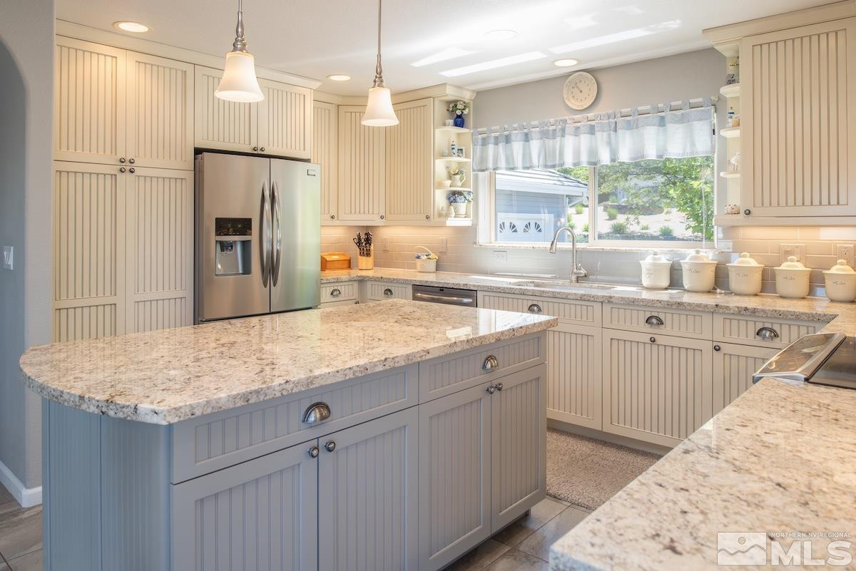 1415 Sioux Trail Reno, NV 89521 - Photo 12 of 40 a kitchen with stainless steel appliances kitchen island granite countertop a sink refrigerator and cabinets