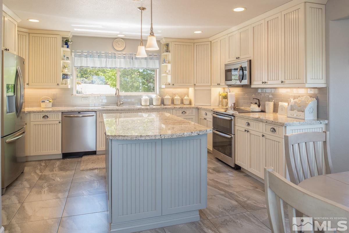 1415 Sioux Trail Reno, NV 89521 - Photo 14 of 40 a kitchen with kitchen island granite countertop a sink counter top space appliances and cabinets