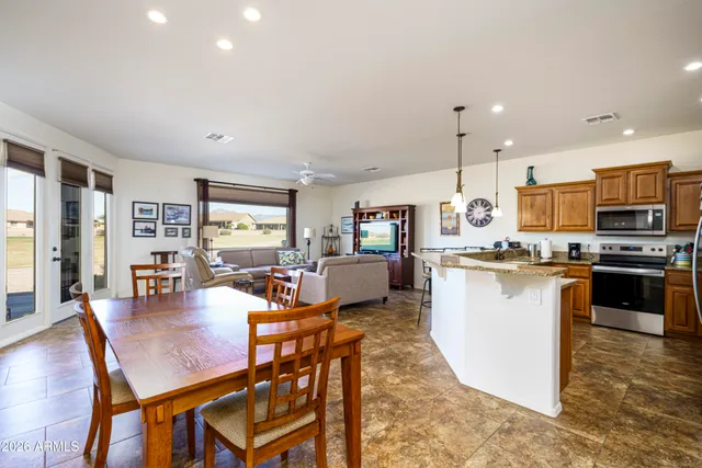 a kitchen with a dining table chairs stove refrigerator and living room view