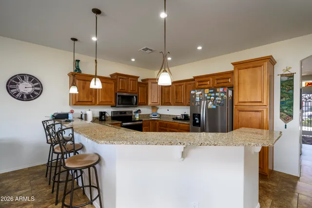 a kitchen with stainless steel appliances kitchen island granite countertop a sink a stove and a refrigerator