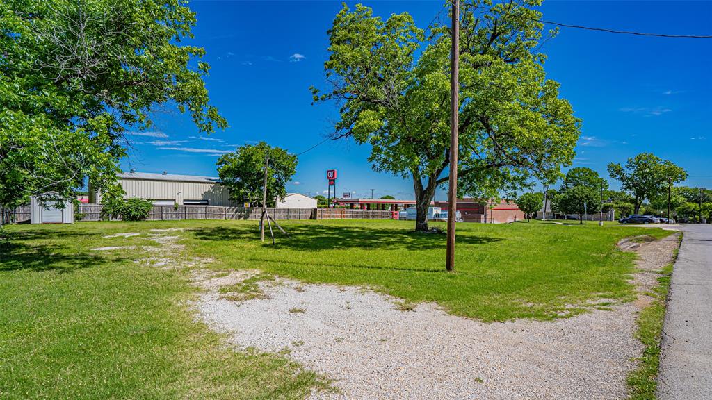 124 Southwest Anderson Street Burleson, TX 76028 - Photo 17 of 36 a view of a house with a big yard and a large tree