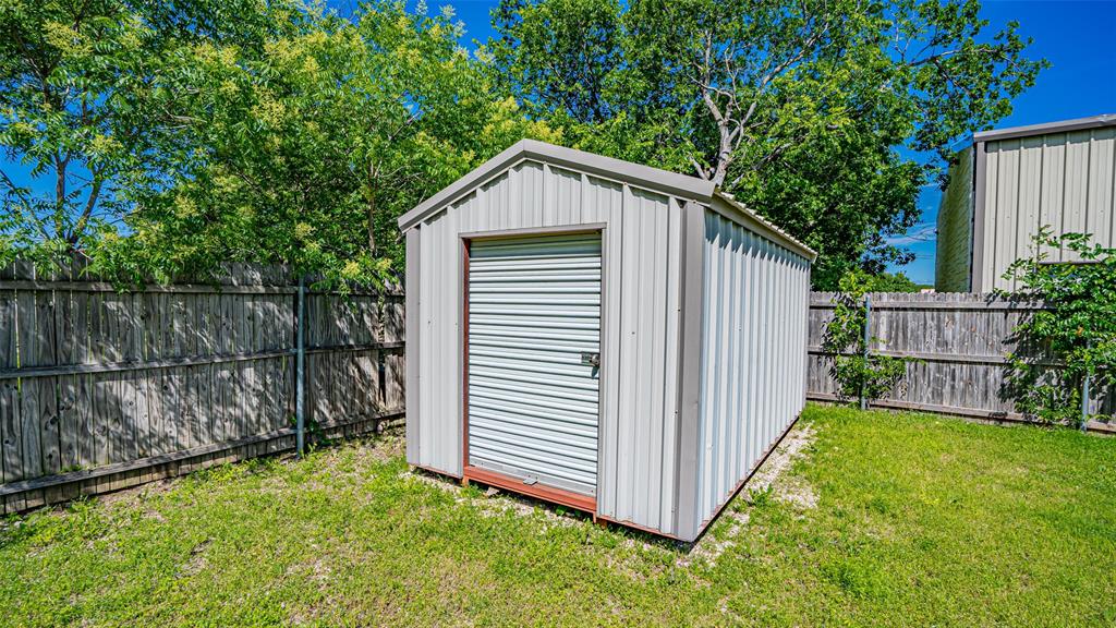 124 Southwest Anderson Street Burleson, TX 76028 - Photo 20 of 36 a view of backyard with small cabin and wooden fence
