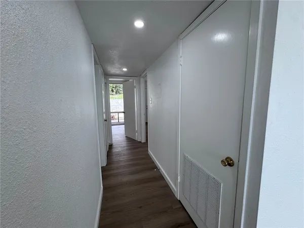 a view of a hallway with wooden floor and closet