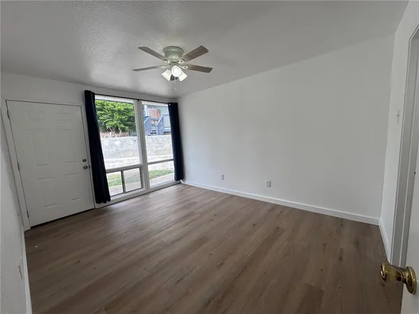 a view of an empty room with wooden floor