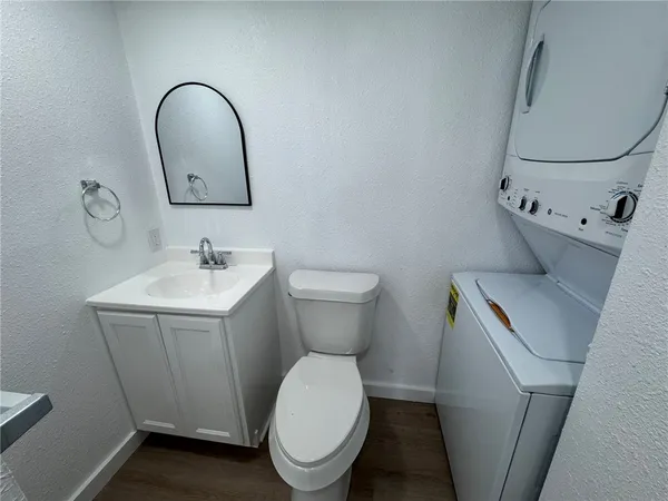 an empty room with wooden floor and ceiling fan