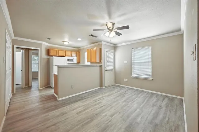 a view of a kitchen with wooden floor and a ceiling fan