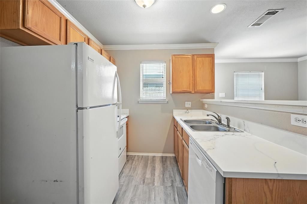 1321 Village Garden Azle, TX 76020 - Photo 8 of 20 a kitchen with a sink a refrigerator a washer and dryer