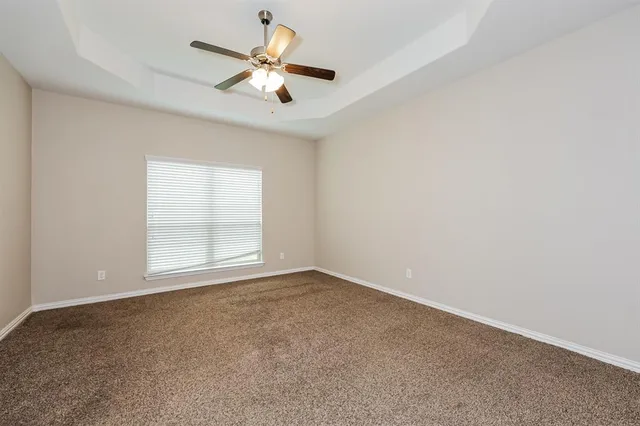 an empty room with a window and a fan