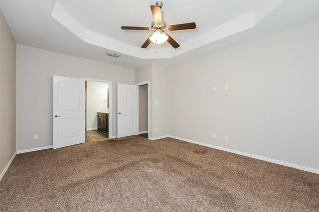 an empty room with closet and a ceiling fan