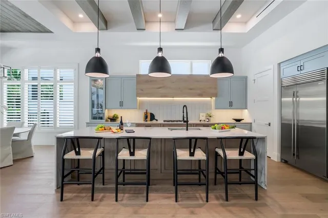 a kitchen with a table chairs refrigerator and cabinets