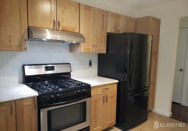 a kitchen with stainless steel appliances granite countertop a stove a refrigerator and a cabinets