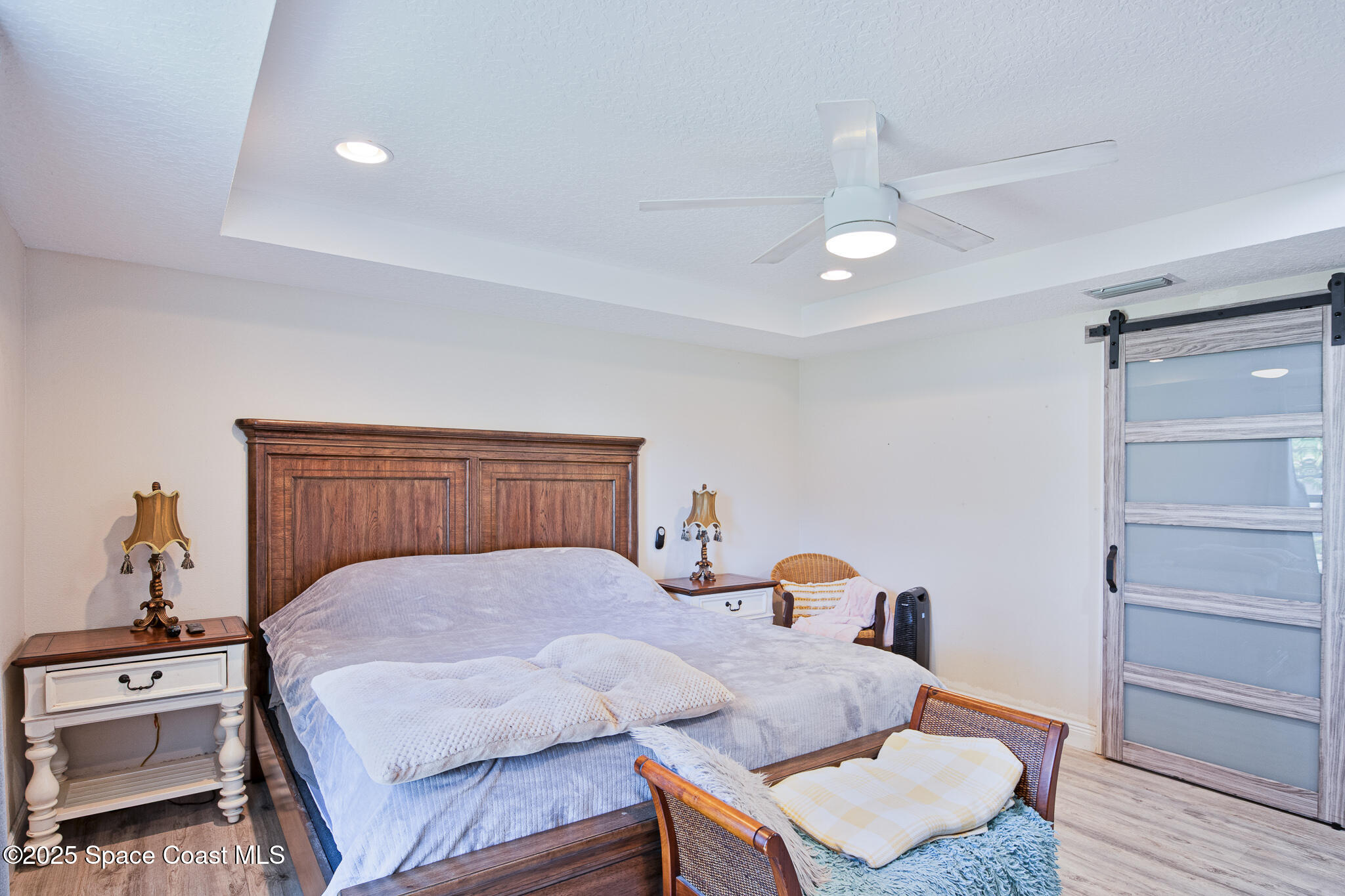 a bedroom with a bed and wooden floor