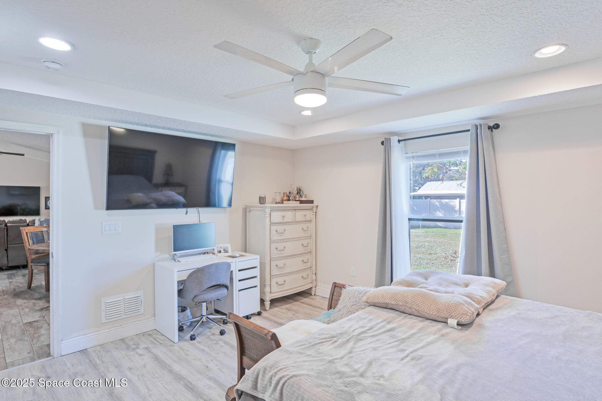 7350 Barbara Road Cocoa, FL 32927 - Photo 12 of 26 a bedroom with a bed a flat screen tv and a dresser