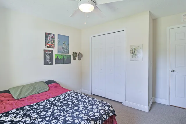 a bedroom with a bed and a painting on the wall