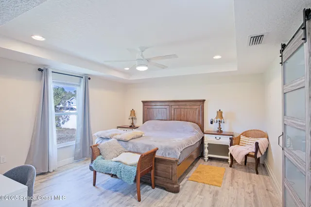 a bedroom with a bed and wooden floor
